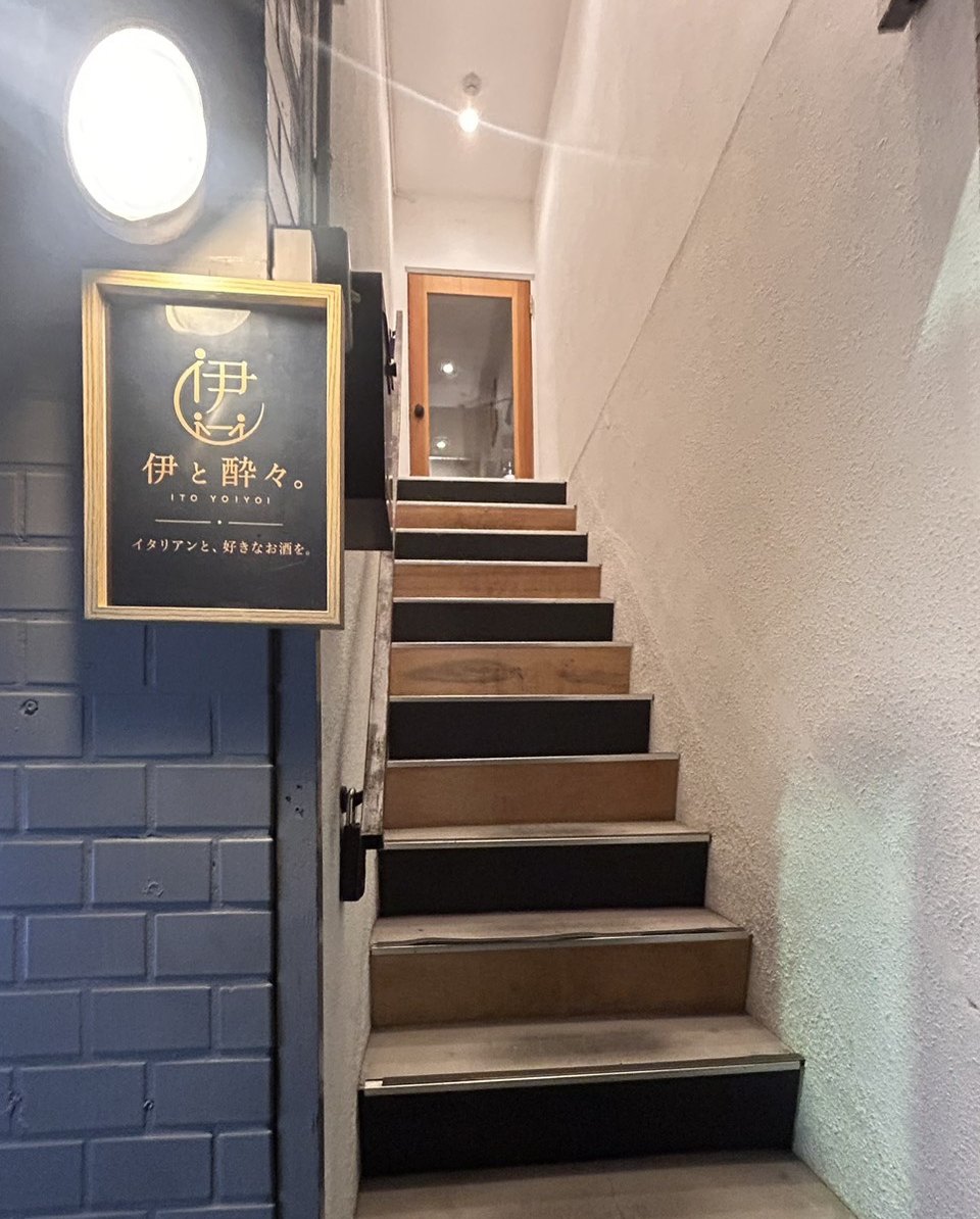 The ITO YOIYOI sign on a blue wall, and the stairs up to the second floor
